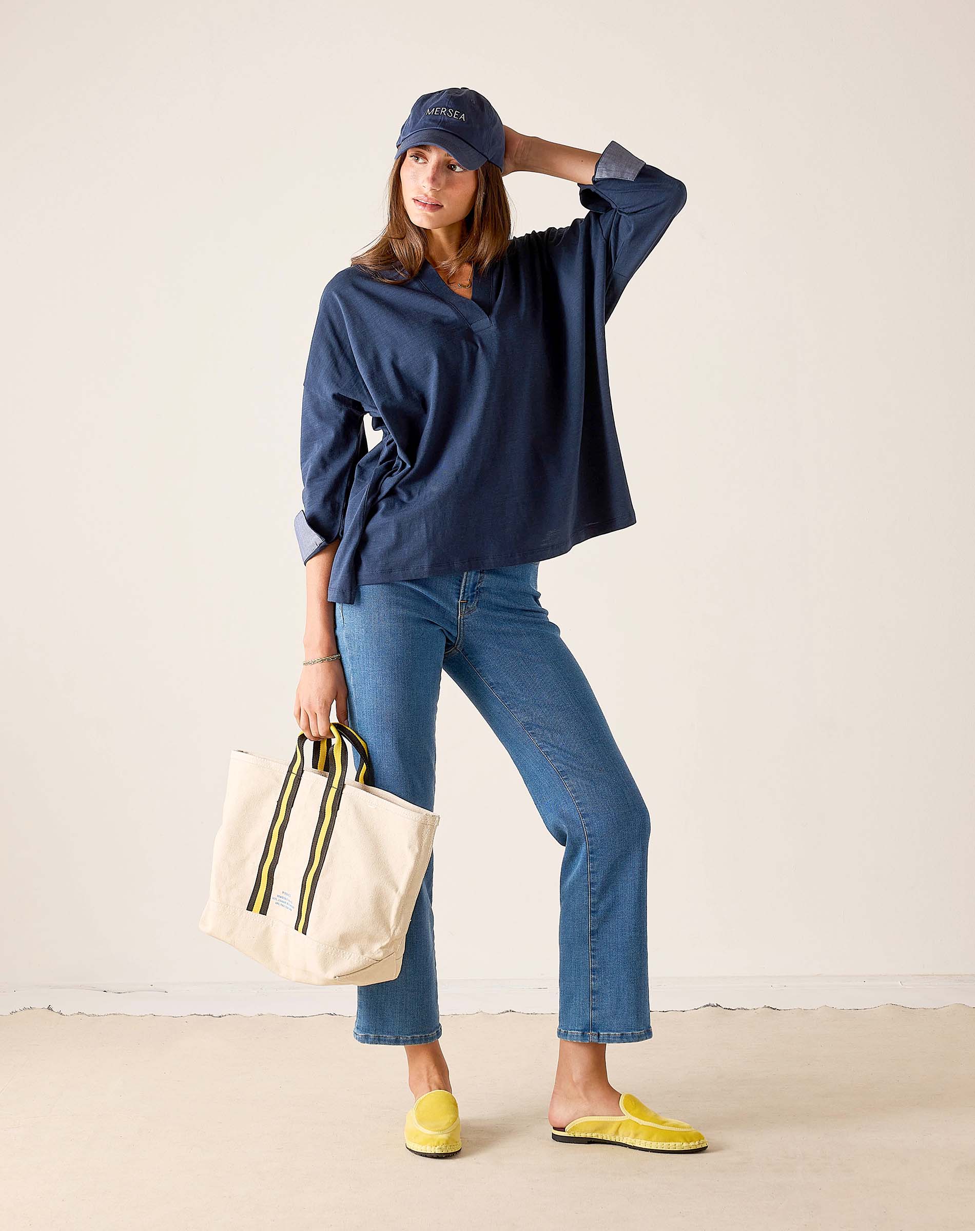 MERSEA ladies' travel-ready navy chambray tee with cuff details and light blue denim jeans.