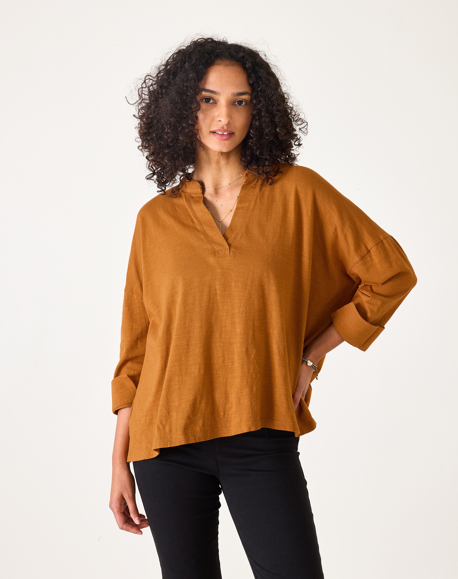 Woman wearing a mustard yellow blouse against a white background