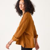 Woman wearing a mustard yellow blouse against a white background