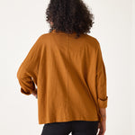 Person wearing a mustard yellow top on a white background