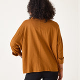 Person wearing a mustard yellow top on a white background