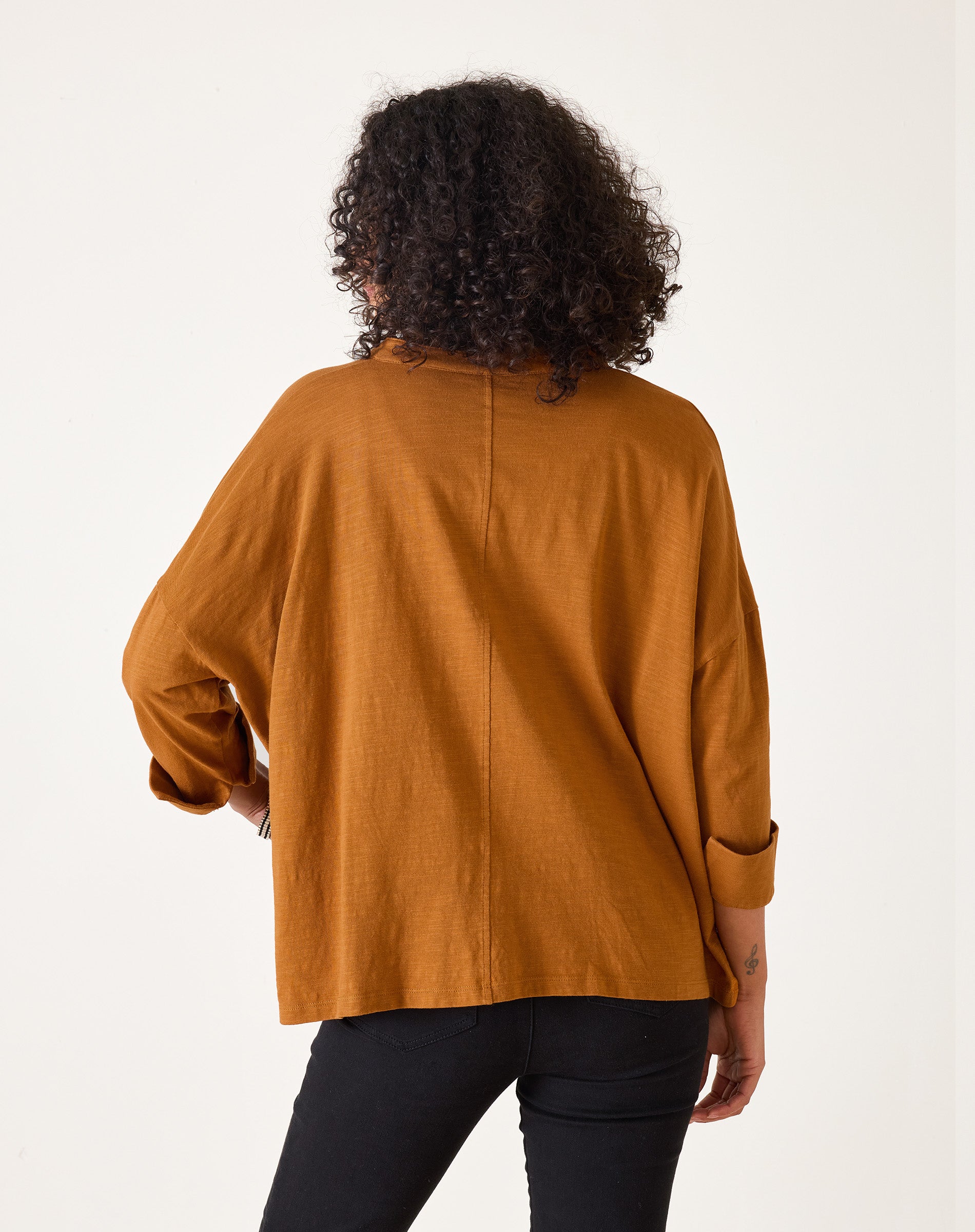Person wearing a mustard yellow top on a white background