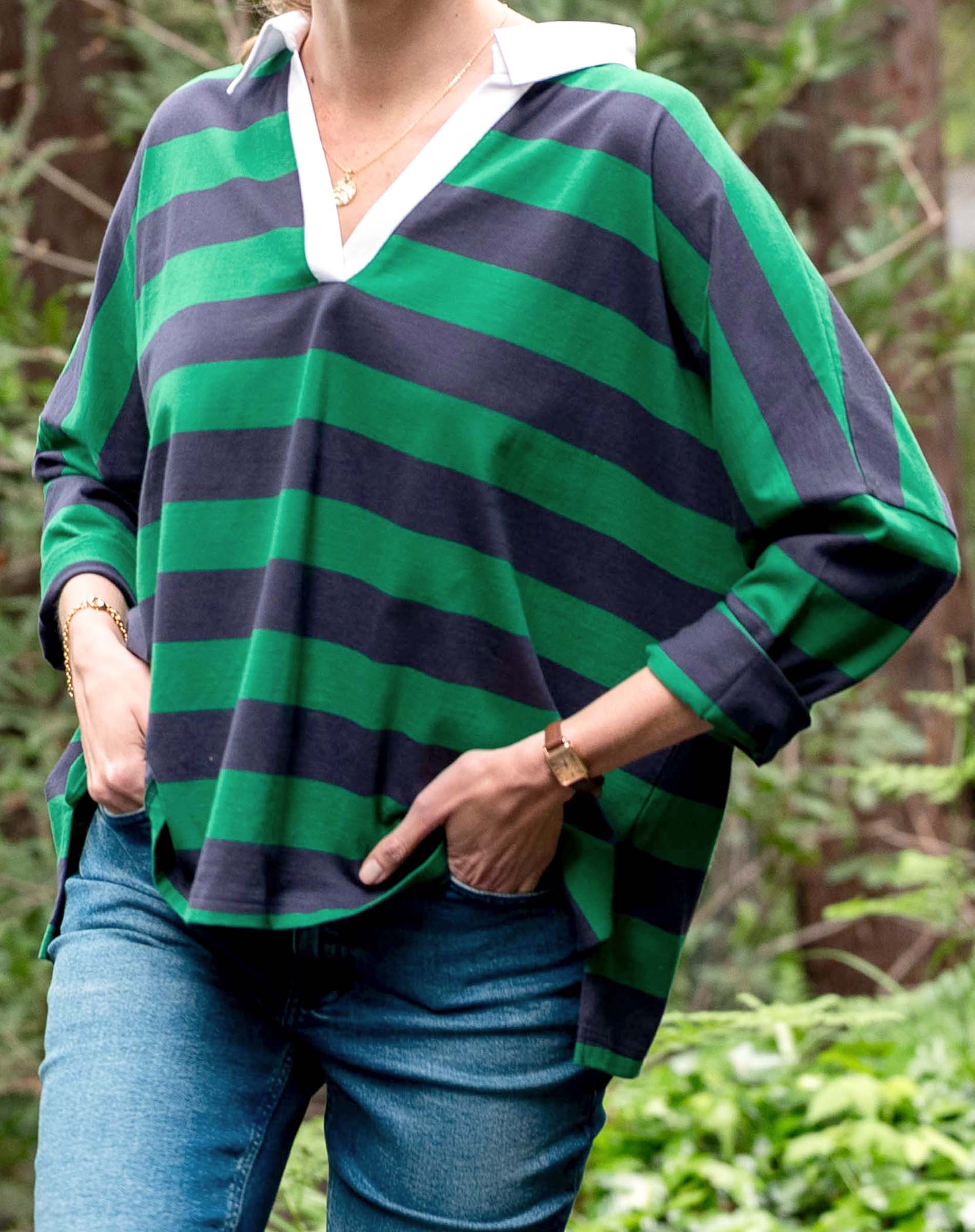Person wearing a green and navy striped shirt with a blurred natural background