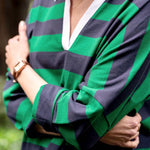 Person wearing a green and navy striped shirt with a blurred background