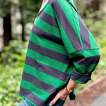 Person wearing a green and navy striped shirt outdoors