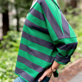 Person wearing a green and navy striped shirt outdoors