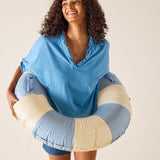 Woman holding a colorful inner tube against a plain background