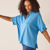 Woman wearing a blue blouse with a plain background