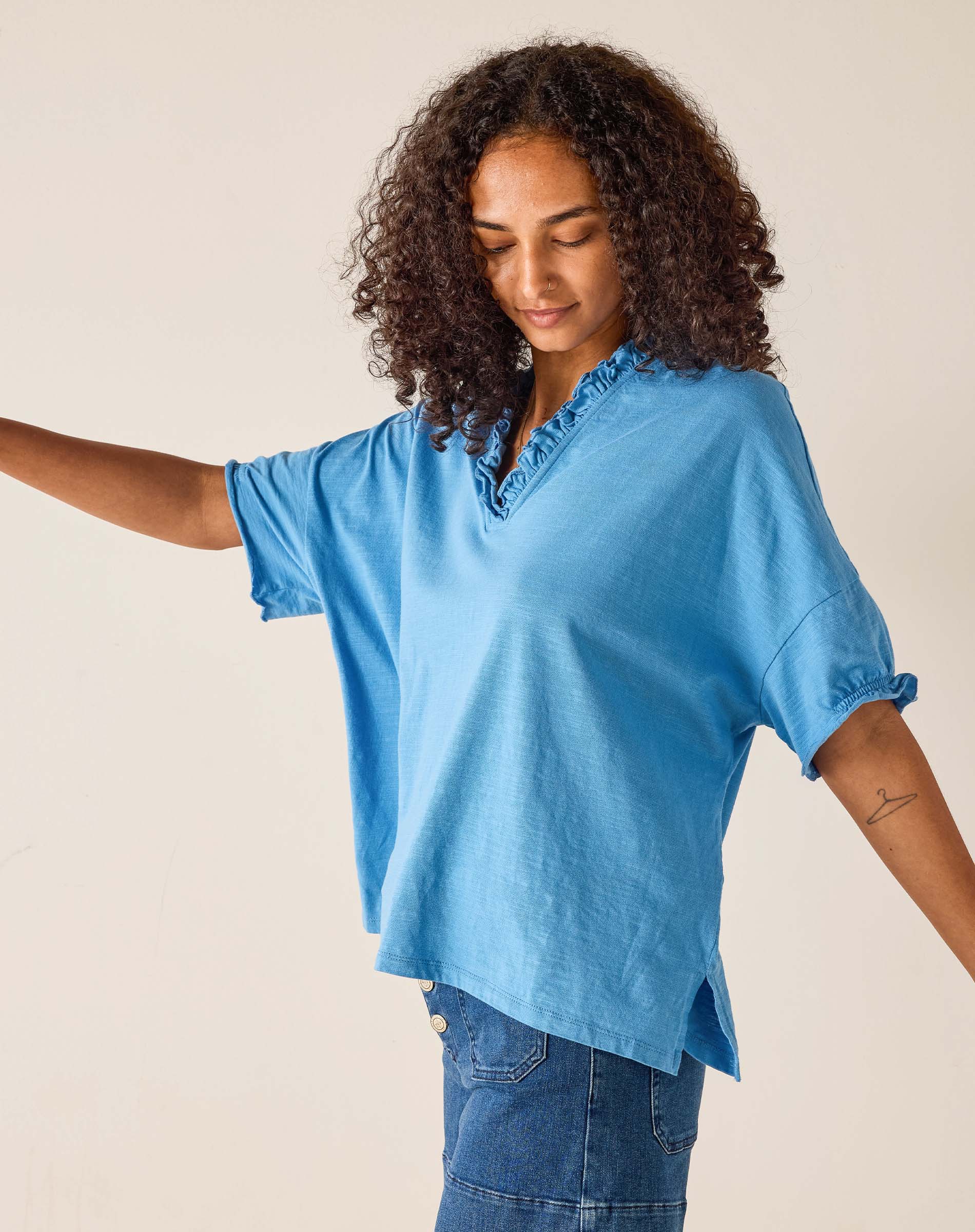 Woman wearing a blue blouse with a plain background