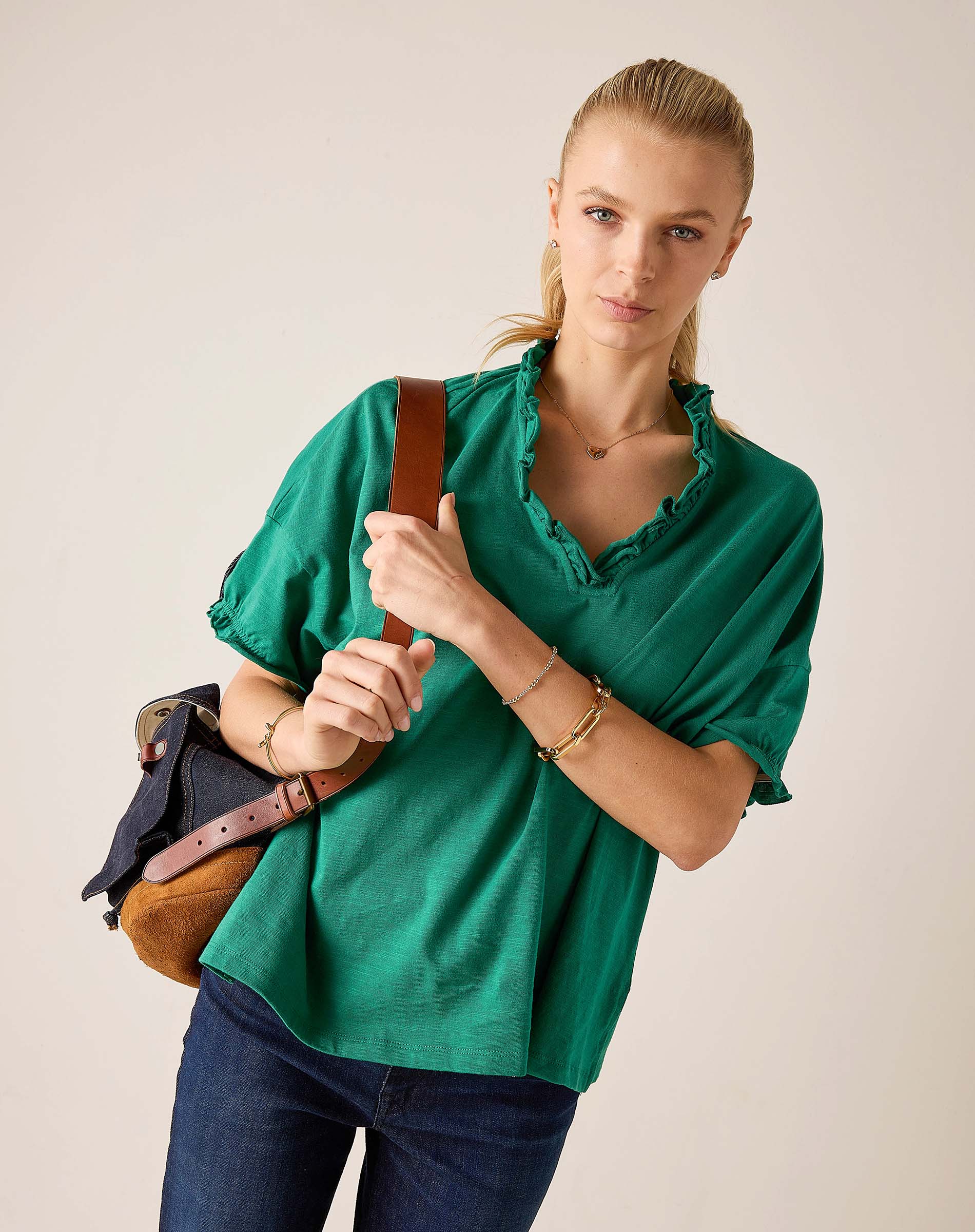 Woman wearing a green blouse with a plain background