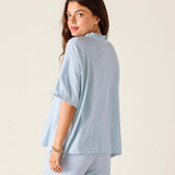 Woman wearing a light blue outfit with a plain background