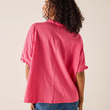 Person wearing a pink shirt and blue jeans on a beige background