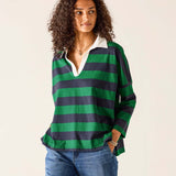 Woman wearing a green and navy striped shirt with a white collar on a beige background