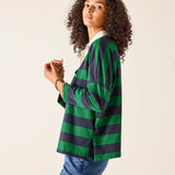 Person wearing a green and navy striped cardigan on a beige background