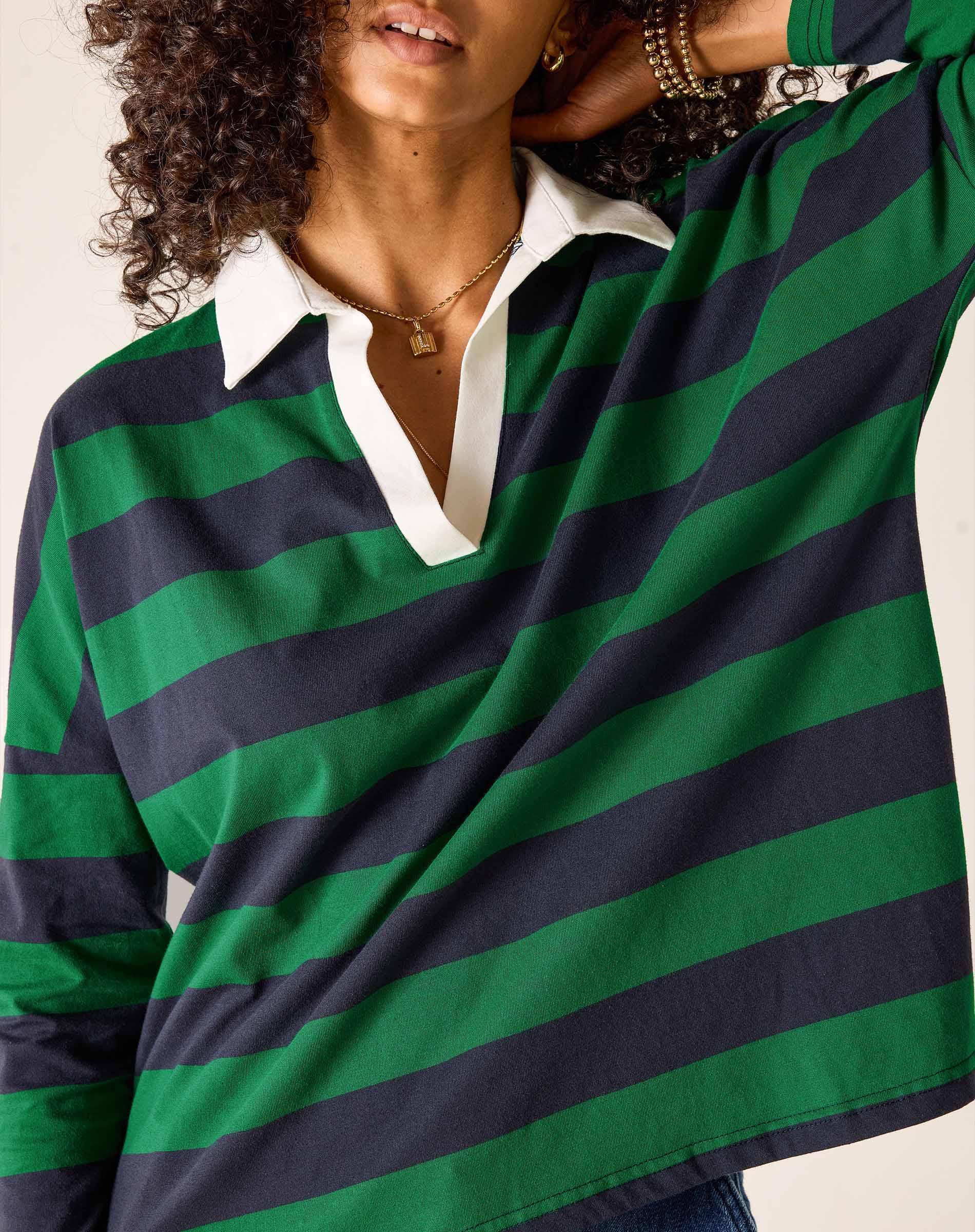 Person wearing a green and navy striped shirt with a white collar.