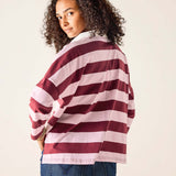 Person wearing a red and white striped sweater against a plain background