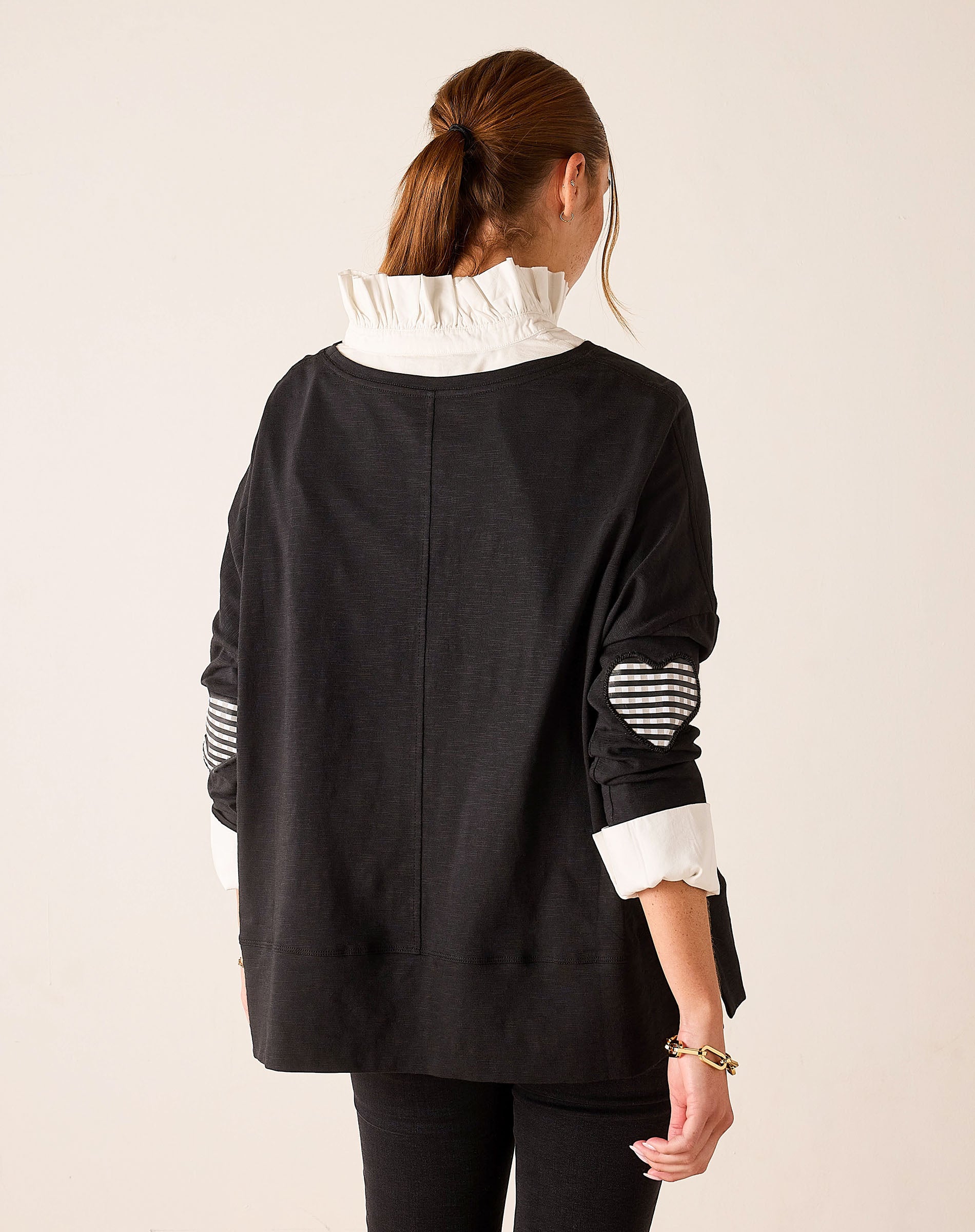 Back view of women's travel-friendly black and white gingham applique tee featuring a relaxed fit and layered ruffle detail.