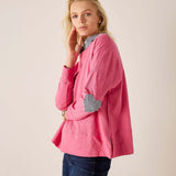 Rapture rose top with a navy stripe heart applique on the sleeve and pair of denim jeans.