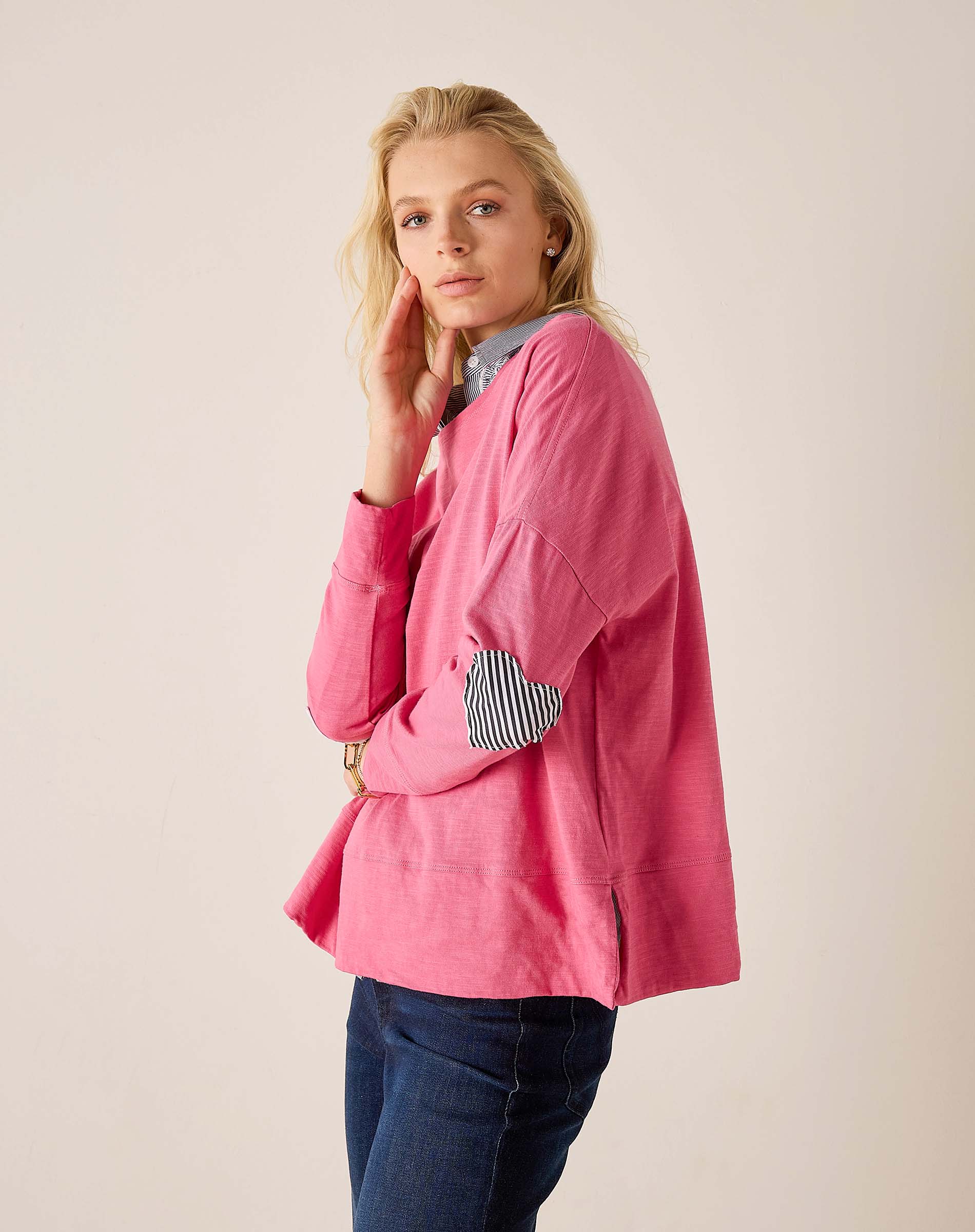 Rapture rose top with a navy stripe heart applique on the sleeve and pair of denim jeans.