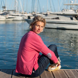 Rose pink t-shirt with navy striped and heart applique details on a model at a harbor.