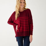 maroon sweater with red stripes and a navy heart elbow patch with dark jeans on white background