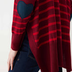 maroon sweater with red stripes and a navy heart elbow patch backwards on white background