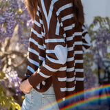 Side view of a chocolate icing brown and blue oversized knit sweater with wide stripes.