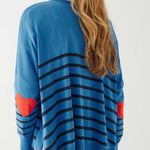 female wearing blue sweater with navy stripes and a red heart elbow patch on white background