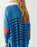 female wearing blue sweater with navy stripes and a red heart elbow patch on white background
