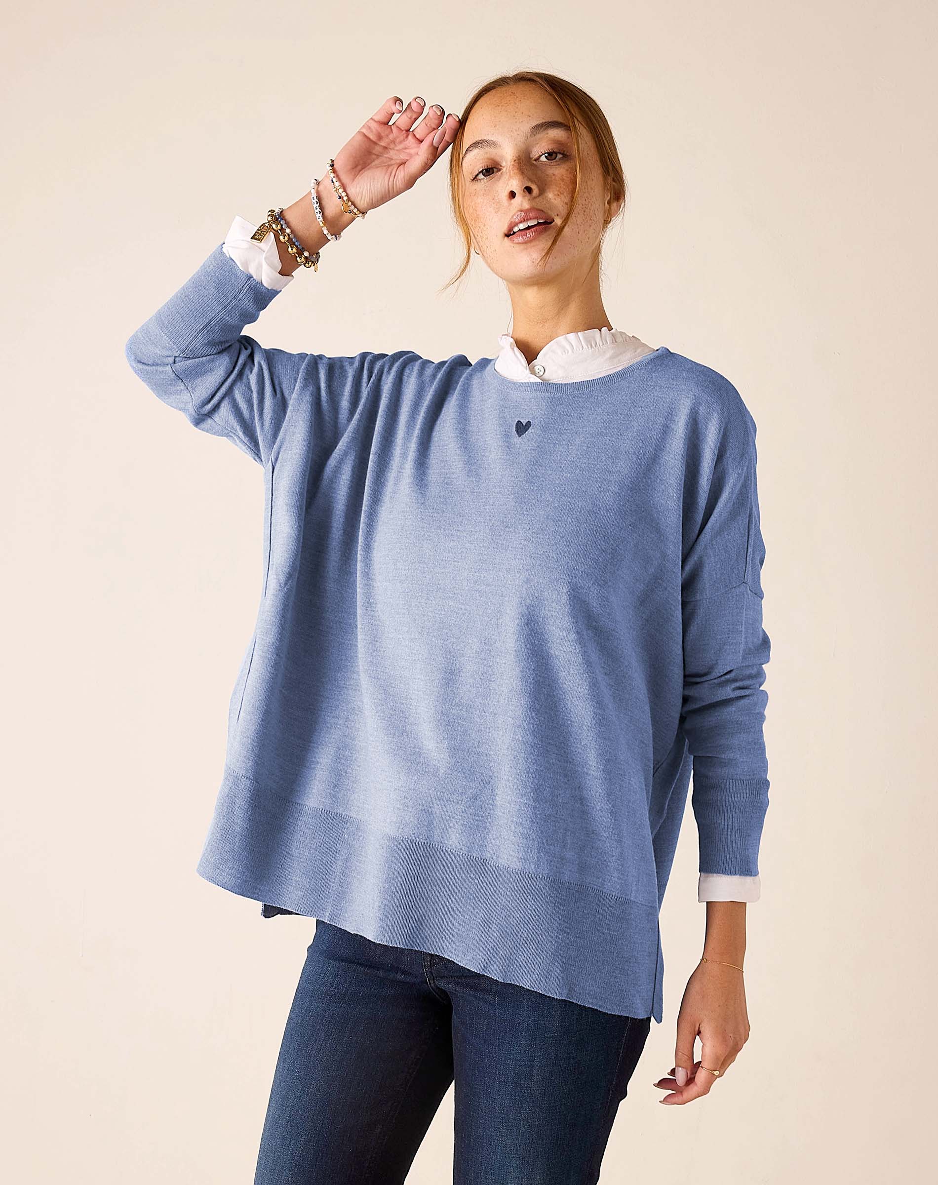Ocean blue knit sweater with a white collar and small heart emblem.