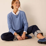Ocean blue knit sweater with a small heart detail and high-waisted navy pants with cuffed hems.