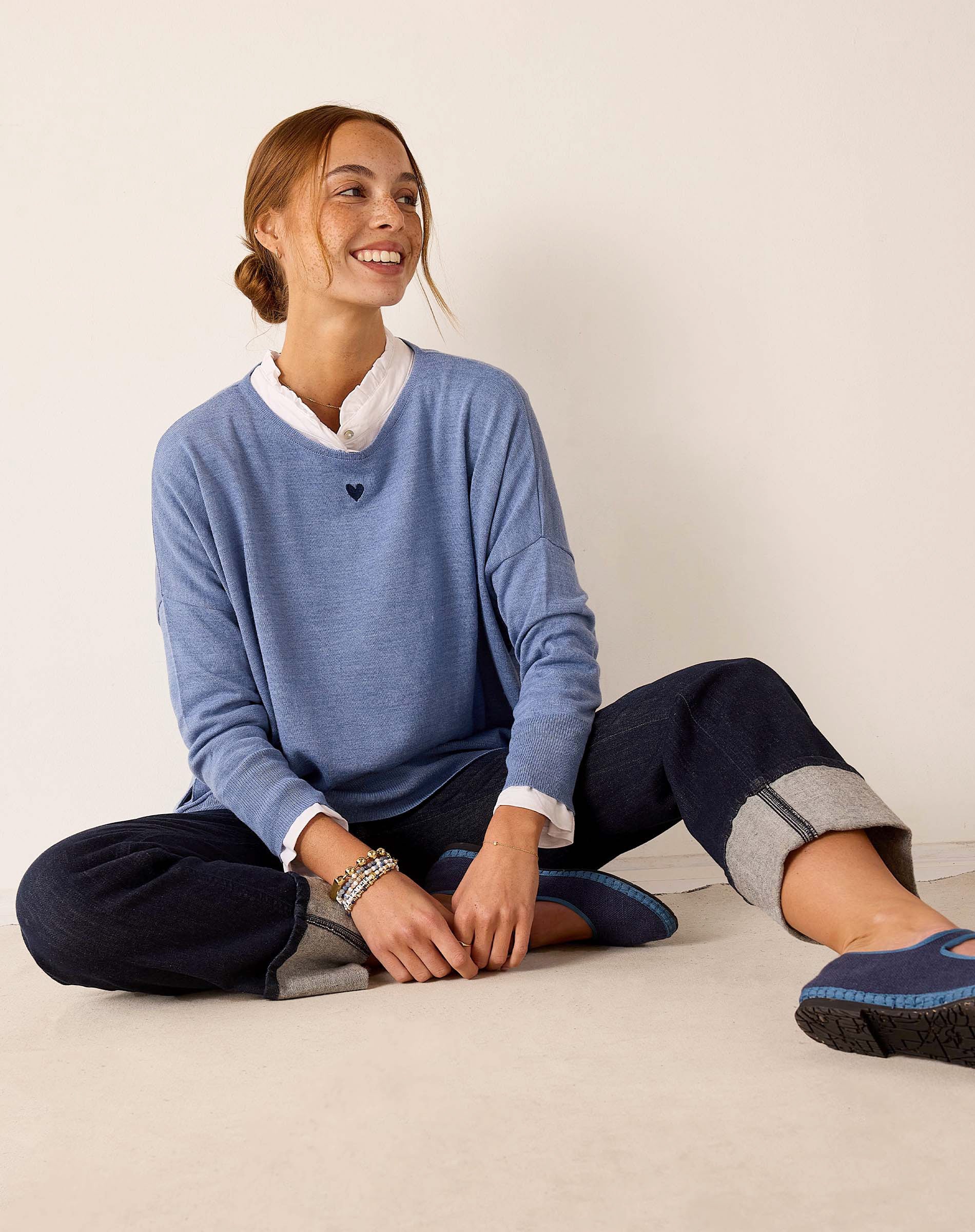 Ocean blue knit sweater with a white collar and heart detail.
