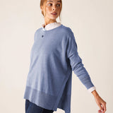 Ocean blue knit sweater with a split side hem and long sleeves over a white shirt.