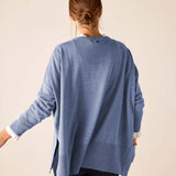 Back view of the ocean blue knit sweater with a relaxed fit and side slits.