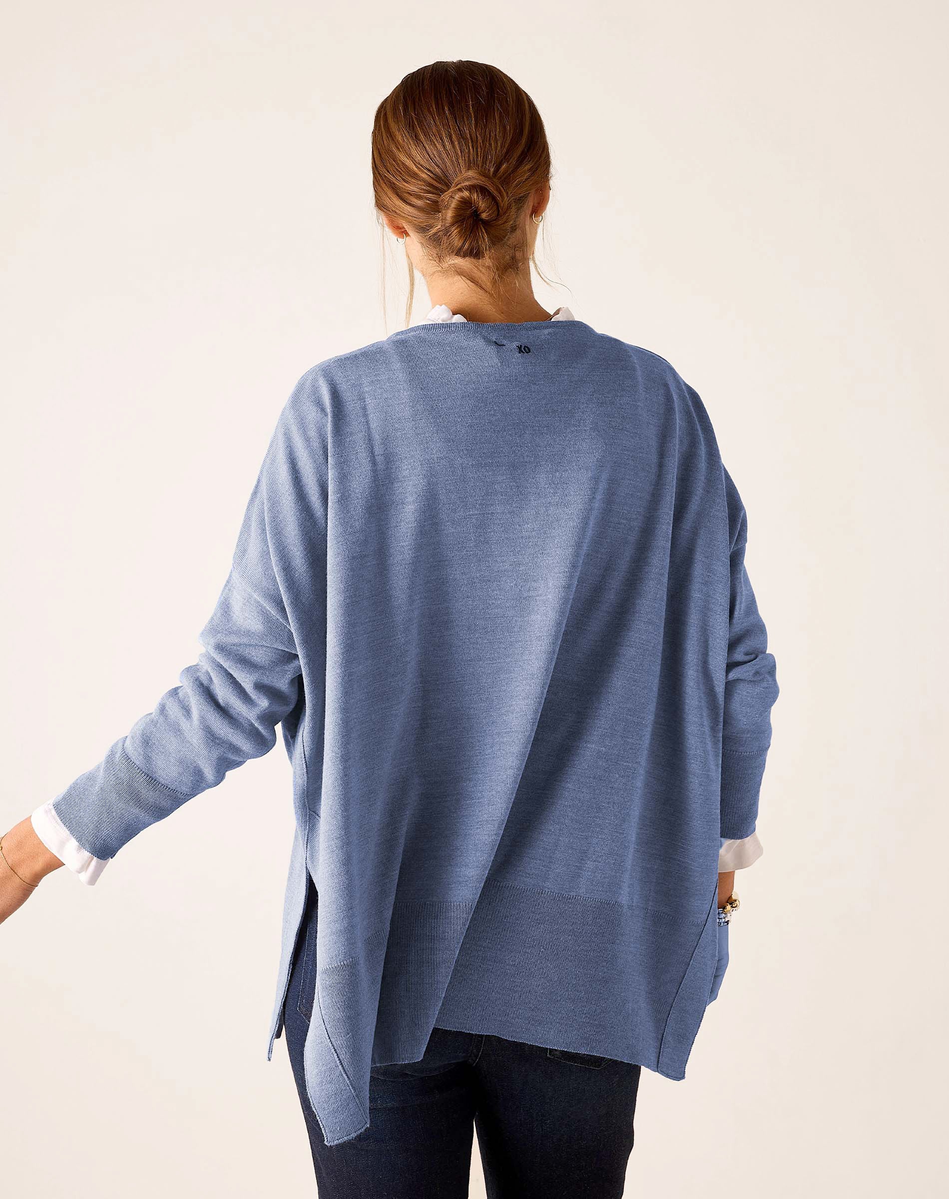 Back view of women's travel-friendly ocean blue knit sweater with a draped back and long sleeves.