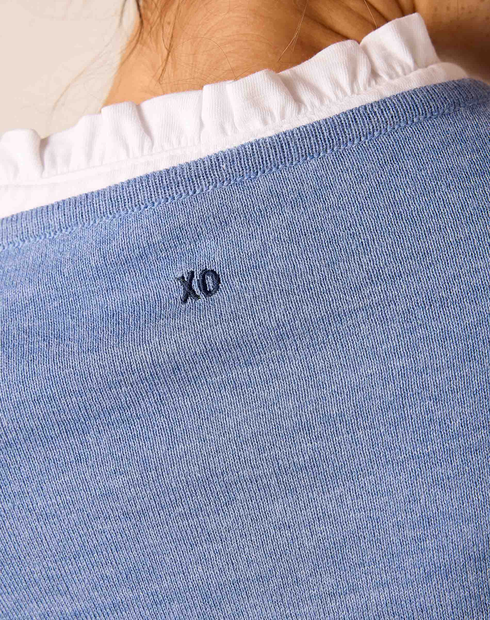 Close-up of the ocean blue knit texture and 'XO' embroidery on the Amour sweater.