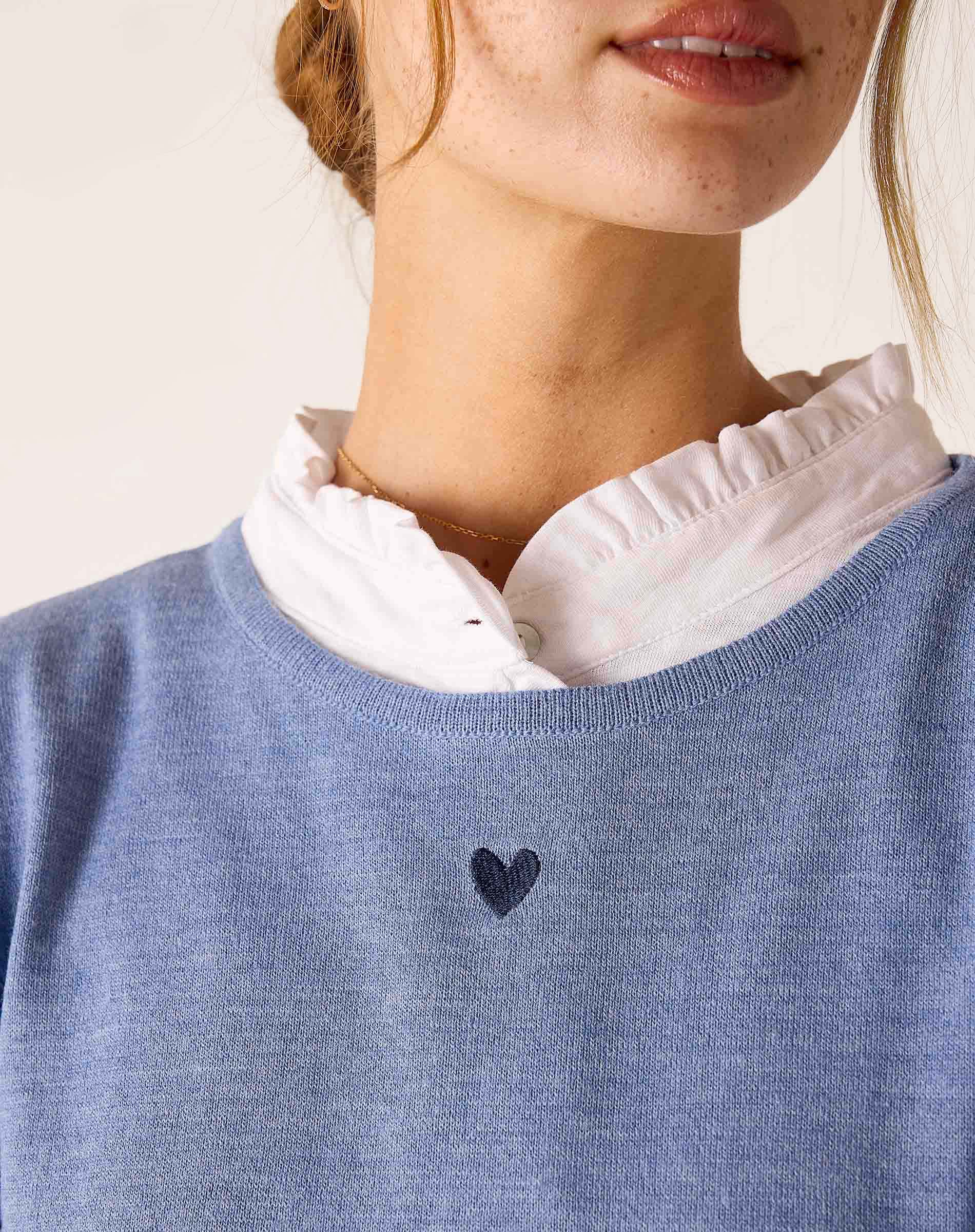 Ocean blue knit sweater featuring a small dark heart detail at the center of the chest.