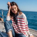 Red and white striped knit sweater with a navy heart-patterned scarf tied at the neck.