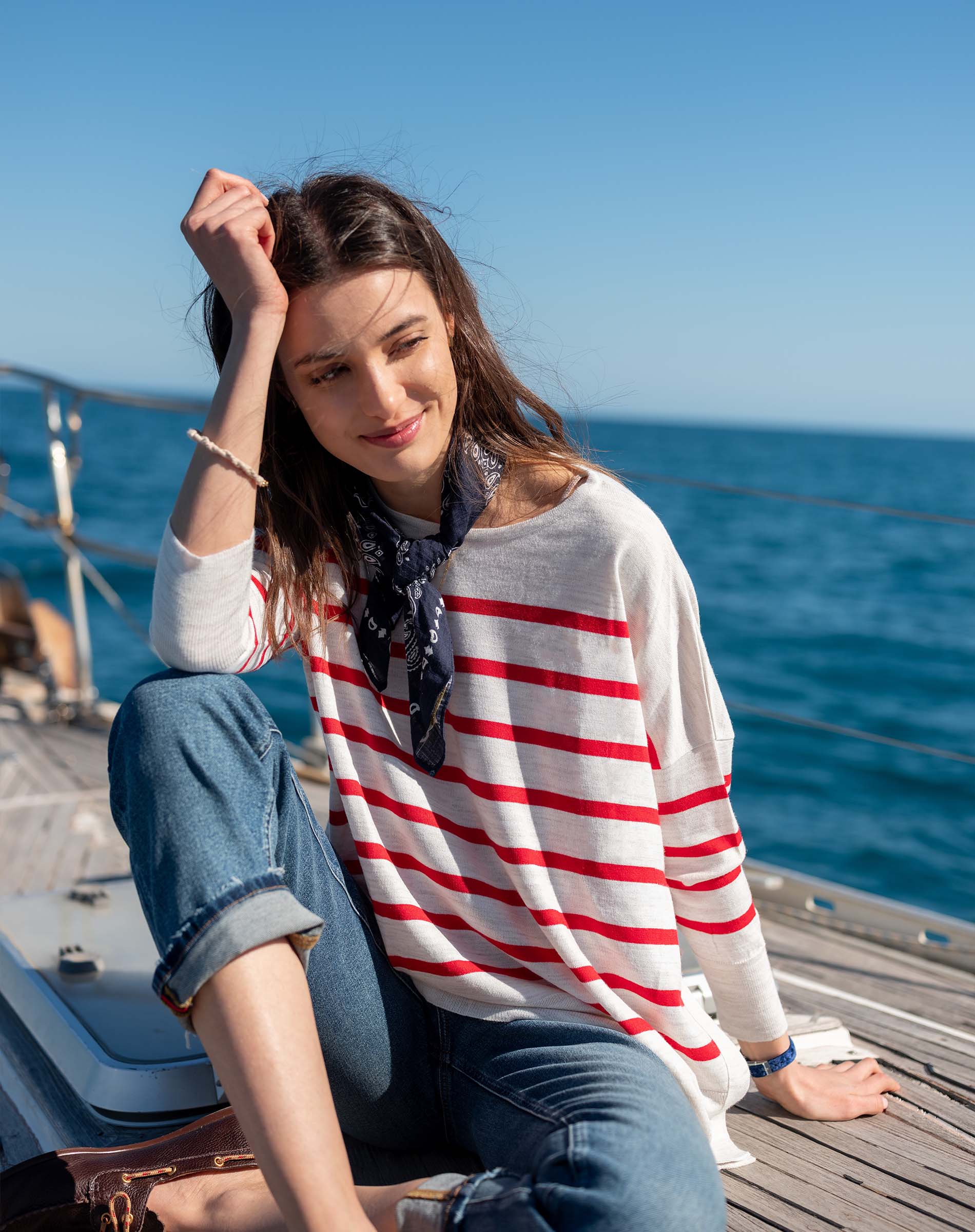 Red and white striped knit sweater with a navy heart-patterned scarf tied at the neck.
