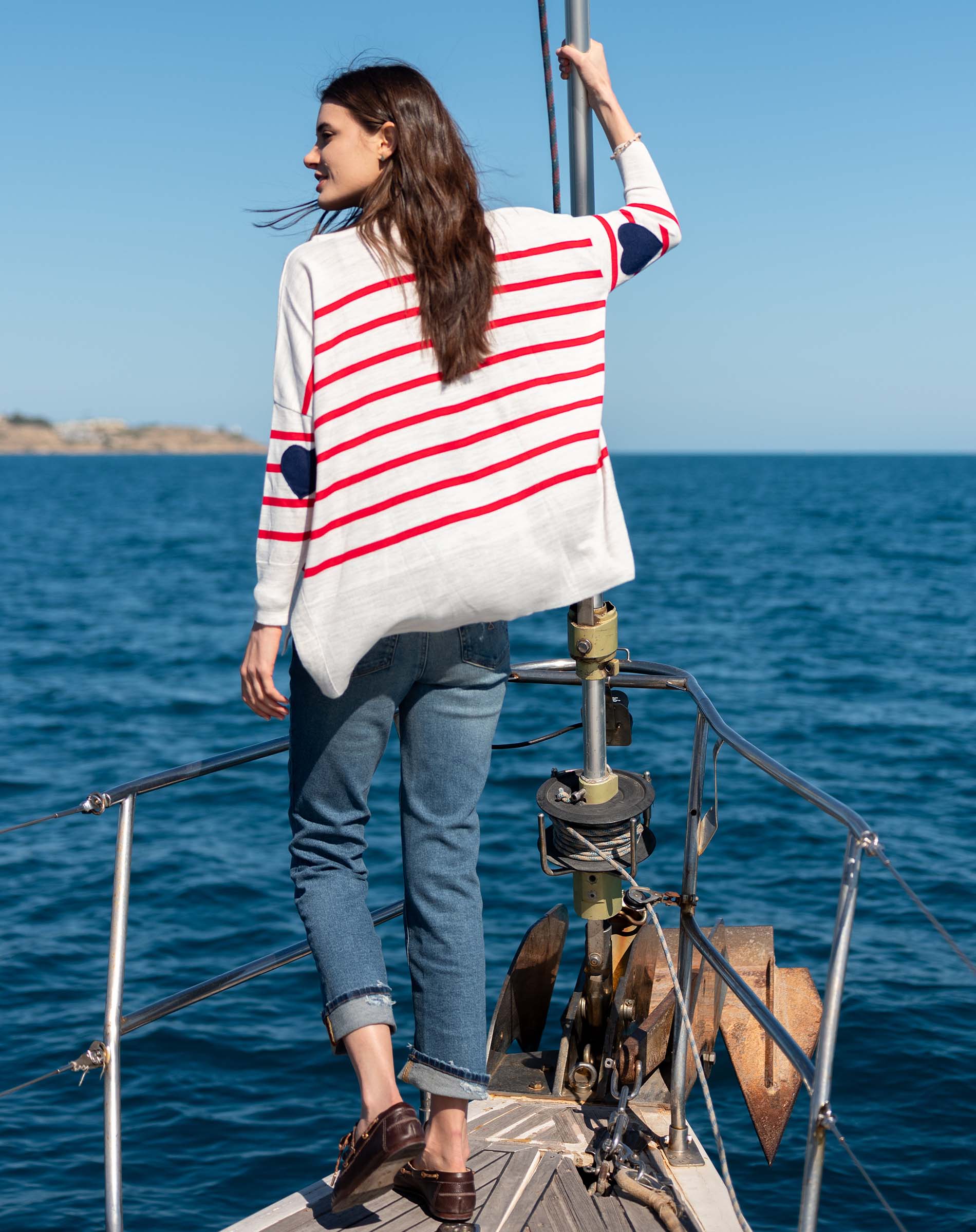 Back view of the white knit sweater with red stripes and navy heart accents.