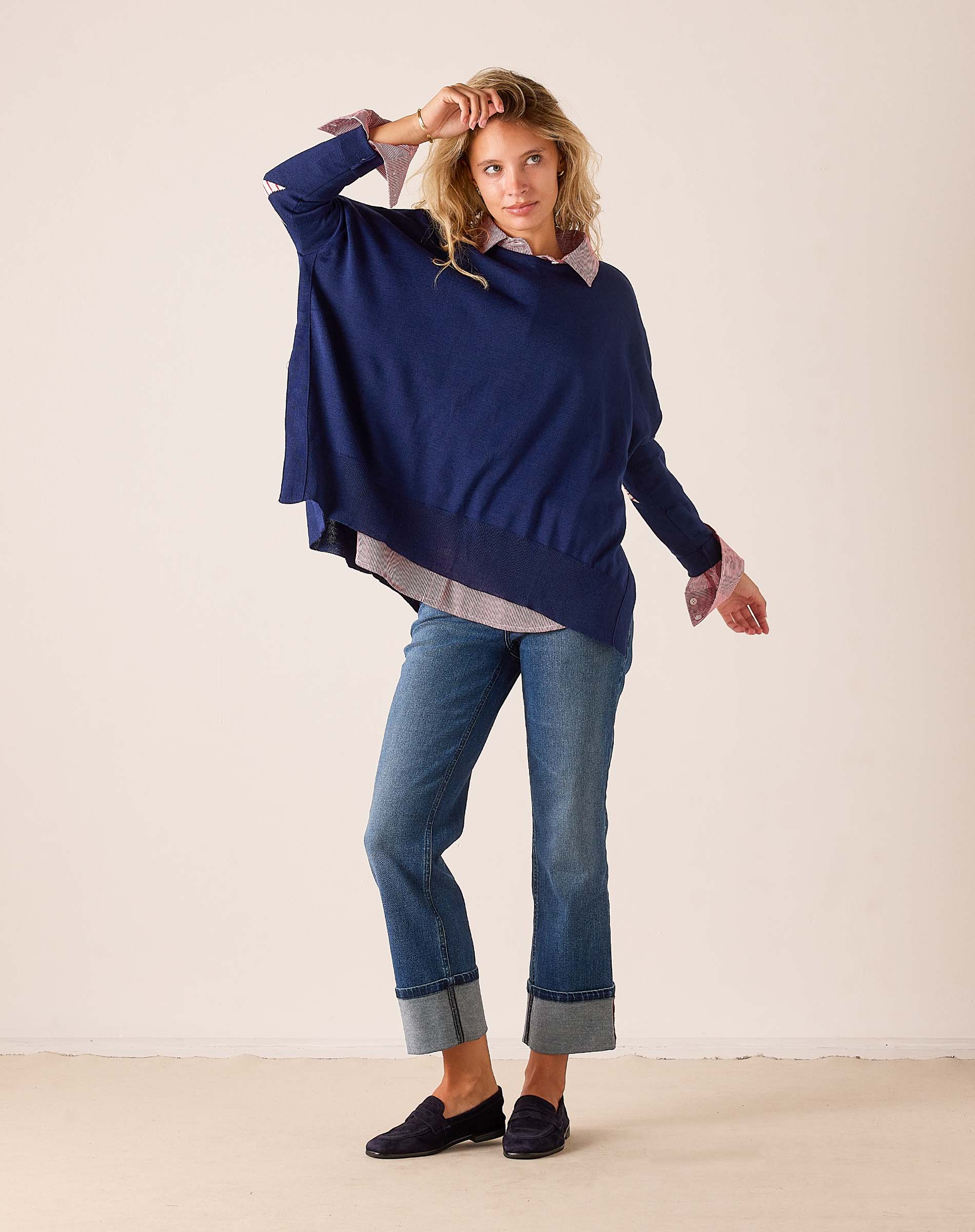 Navy blue oversized knit sweater with stars and stripes detail layered over a patterned button-down shirt.