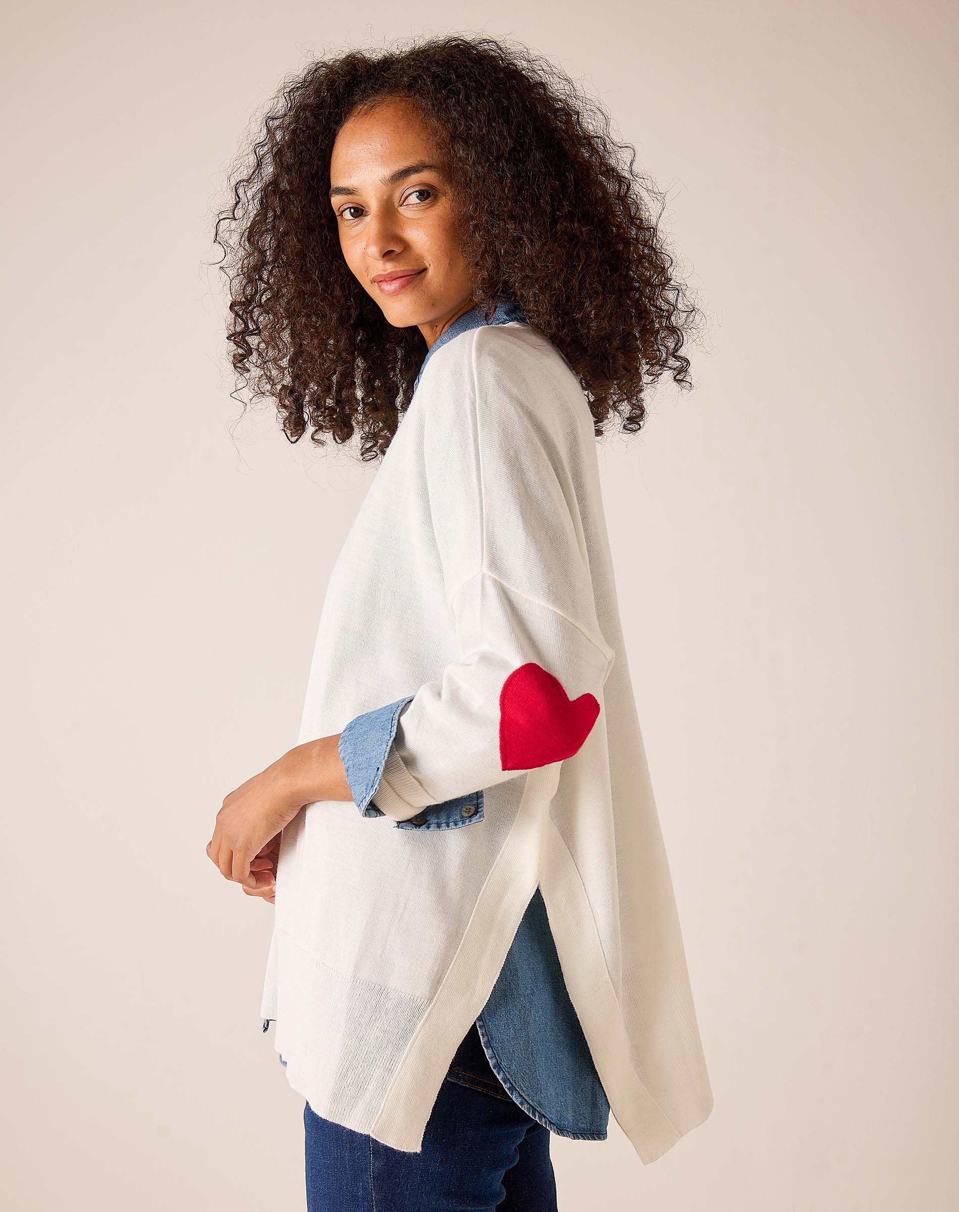 White knit sweater with red heart detail and denim-style accents.