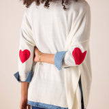White knit sweater with red heart embroidery and denim-trimmed cuffs