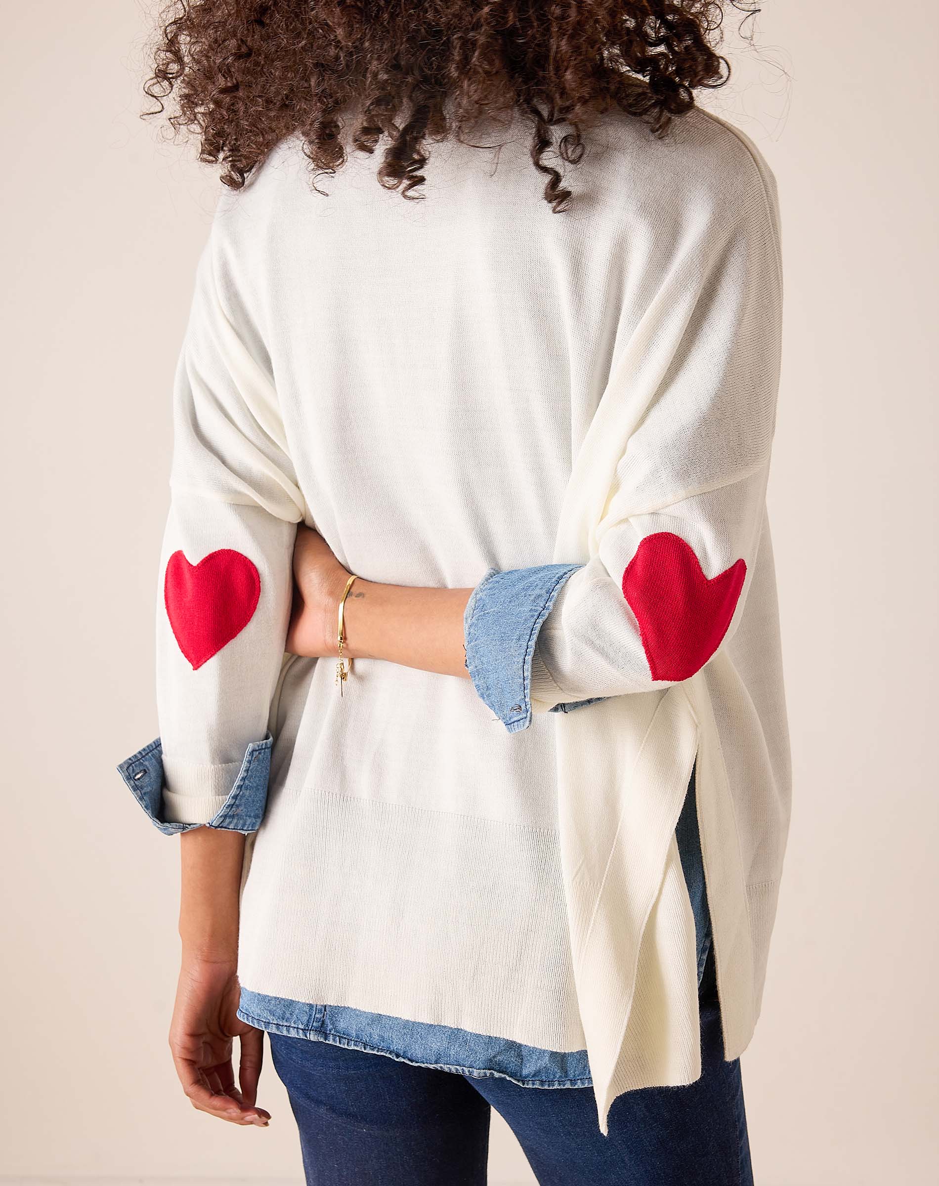 White knit sweater with red heart embroidery and denim-trimmed cuffs