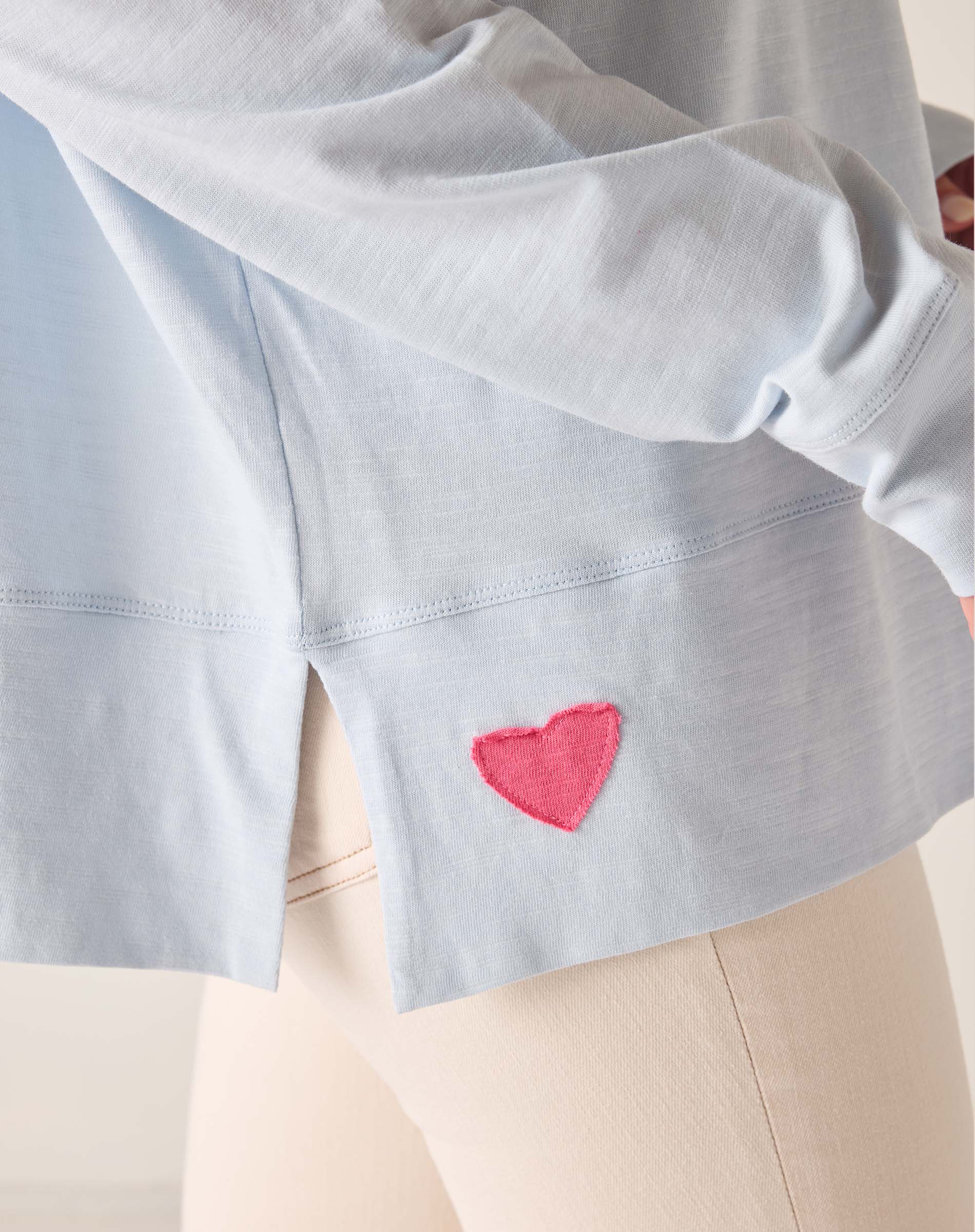 Light blue shirt with a pink heart design on a white background