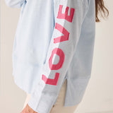 Light blue sweatshirt with pink 'LOVE' text on a plain background