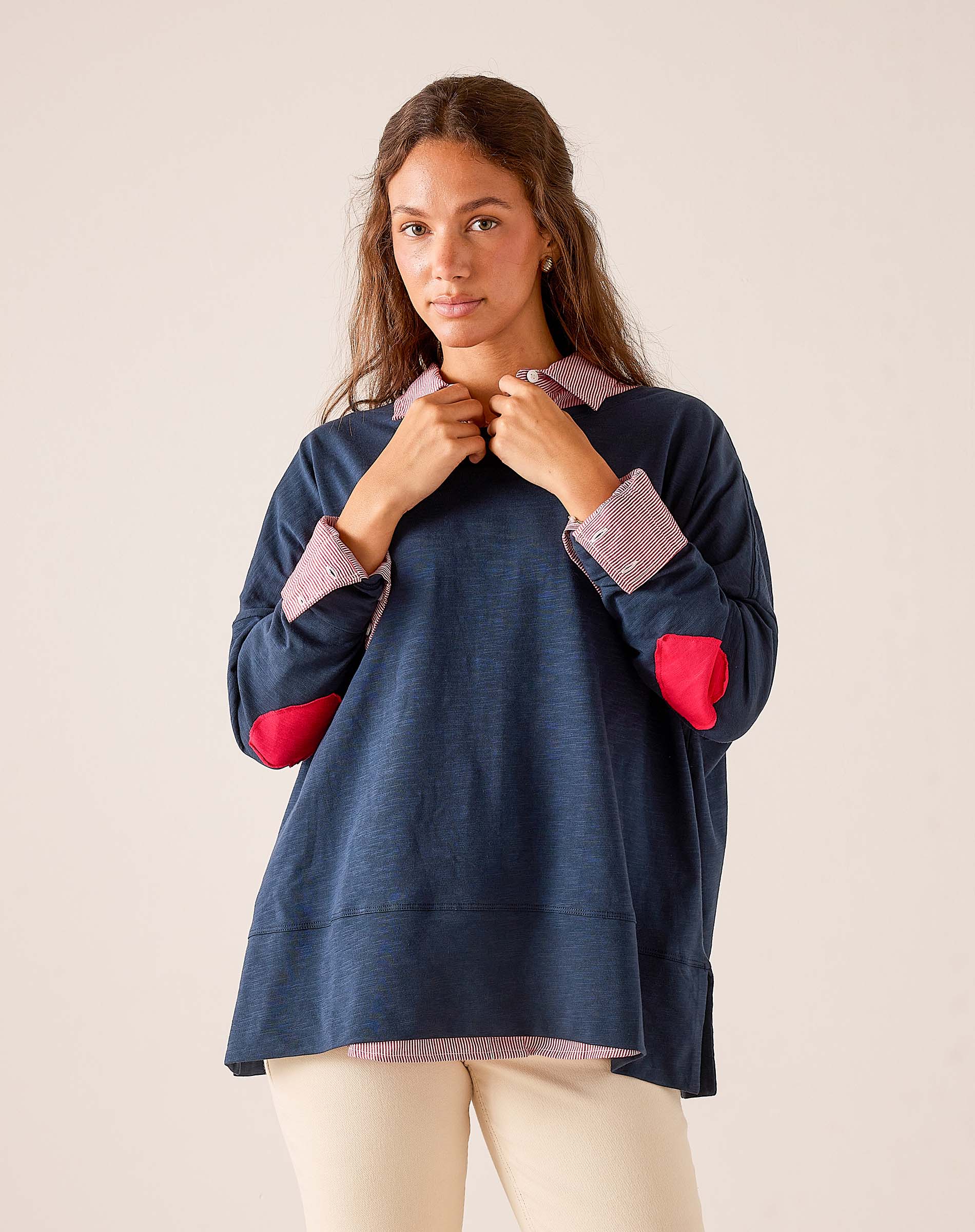 Navy blue oversized t-shirt featuring a striped collar, striped cuffs, and red heart accents on the sleeves.