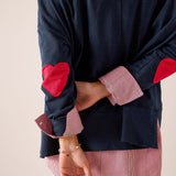 Navy blue oversized tee with red heart appliqués and striped contrast cuffs in a relaxed fit.