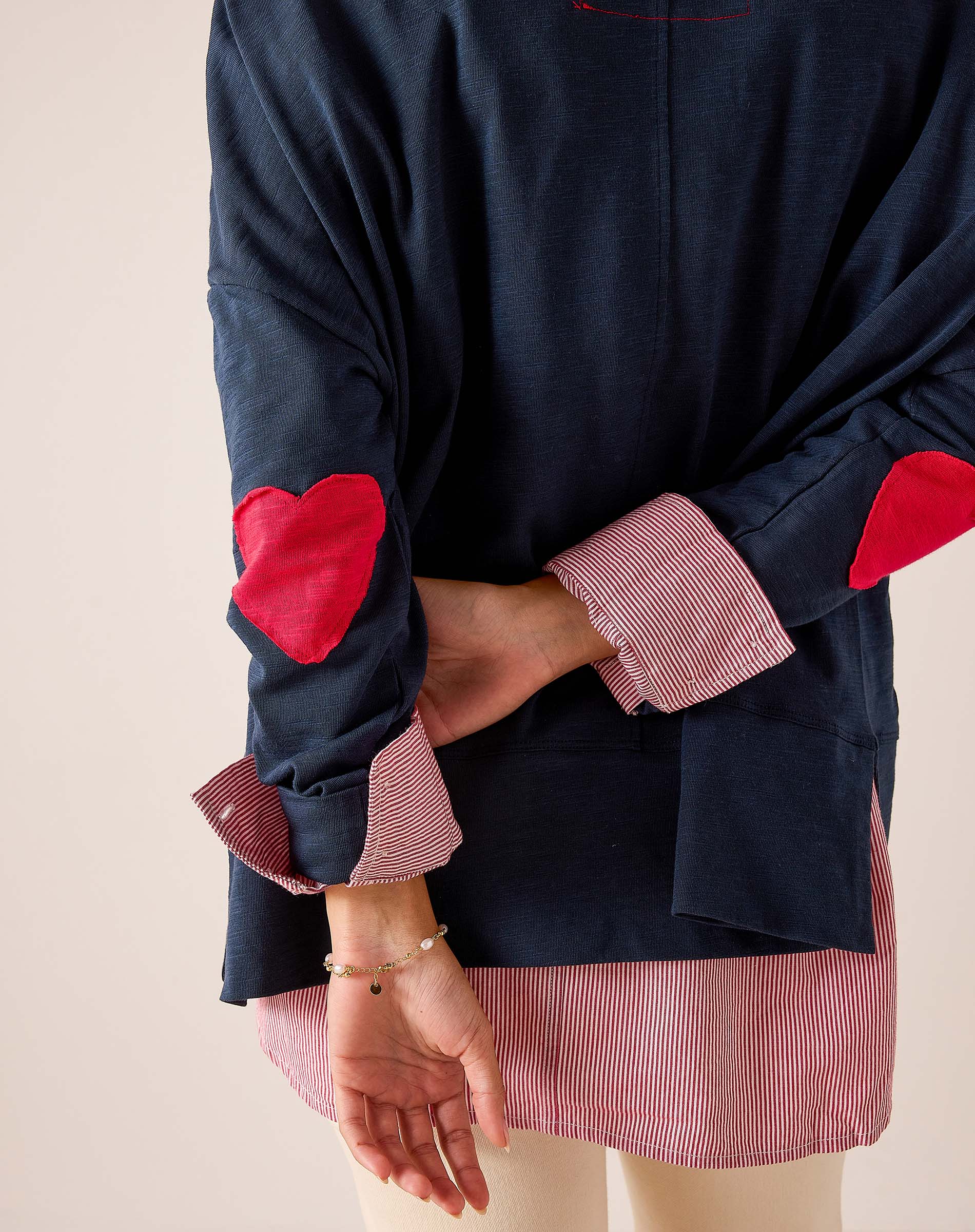 Navy blue oversized tee with red heart appliqués and striped contrast cuffs in a relaxed fit.