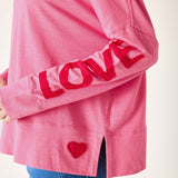 Pink sweatshirt with 'LOVE' and heart design on a white background